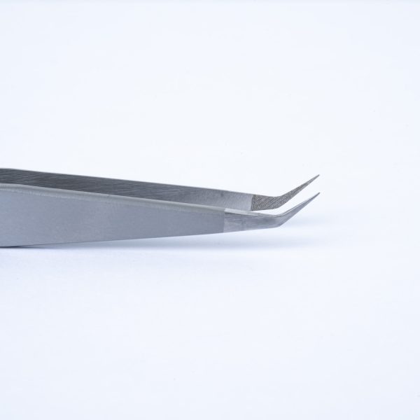 Κοντινή λήψη της μύτης Stiletto 45° της λαβίδας TW-04, ιδανική για ακριβή διαχωρισμό και τοποθέτηση βλεφαρίδων με Fiber Tip