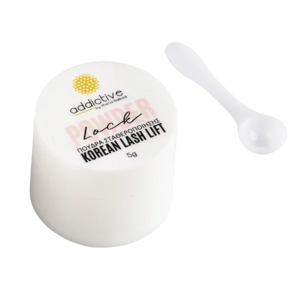 Powder Lock – Πούδρα Σταθεροποίησης Korean Lash Lift (5g) Λευκό βαζάκι της πούδρας σταθεροποίησης Powder Lock (5g) της Addictive Lashes, ειδική για την τεχνική Korean Lash Lift, φωτογραφημένη δίπλα στο λευκό κουταλάκι εφαρμογής.