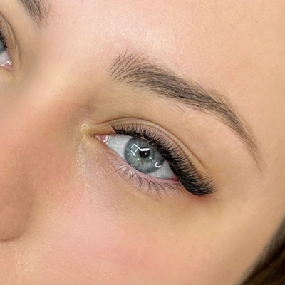 Κοντινή φωτογραφία ματιού με εφαρμογή extensions τεχνικής Fox Eye. Διακρίνεται η ειδική χαρτογράφηση με έμφαση στα μέγιστα μήκη στην εξωτερική γωνία, που δημιουργεί ένα έντονα "τραβηγμένο" και ανορθωτικό βλέμμα, αποτέλεσμα της εξειδικευμένης εκπαίδευσης στο Workshop.